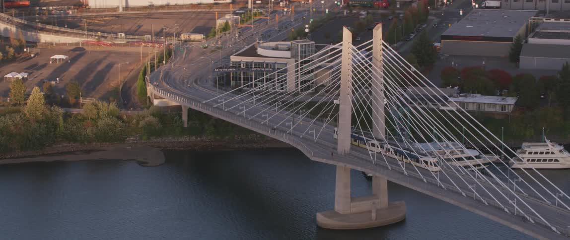 Vehicles driving over a bridge towards a city