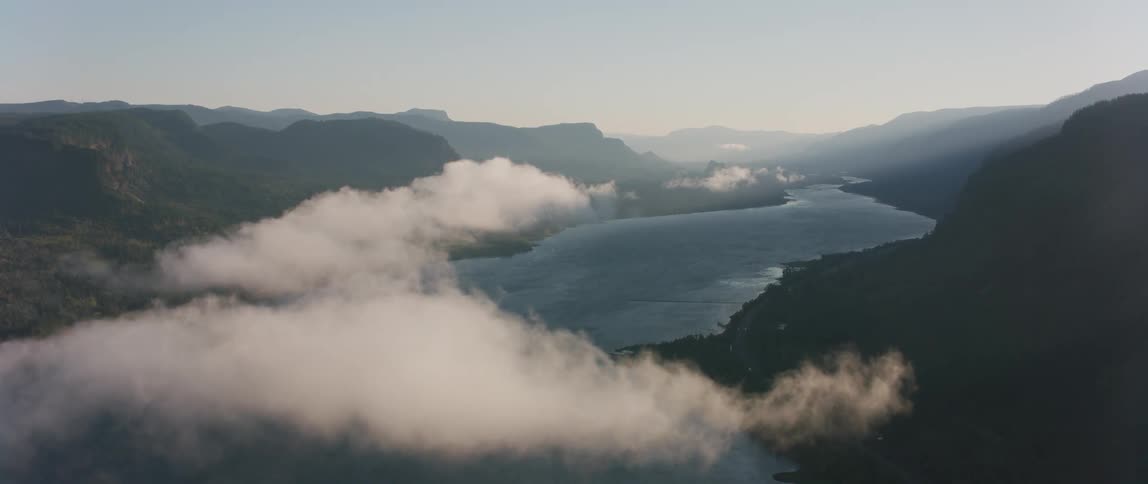 Clouds floating over a river and mountains