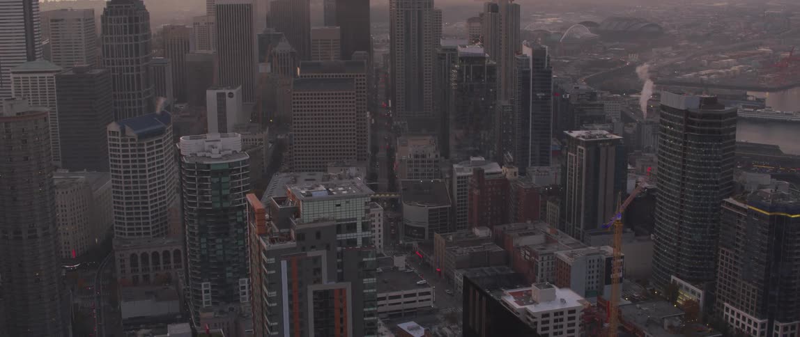 Skyscrapers stand in a city at sunset