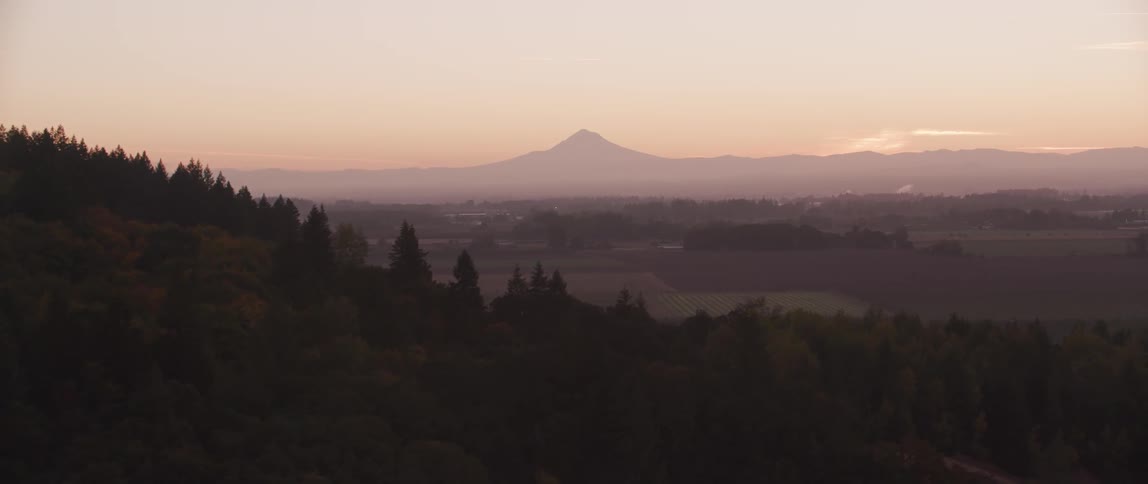 Dusk is falling over a farming community in a valley