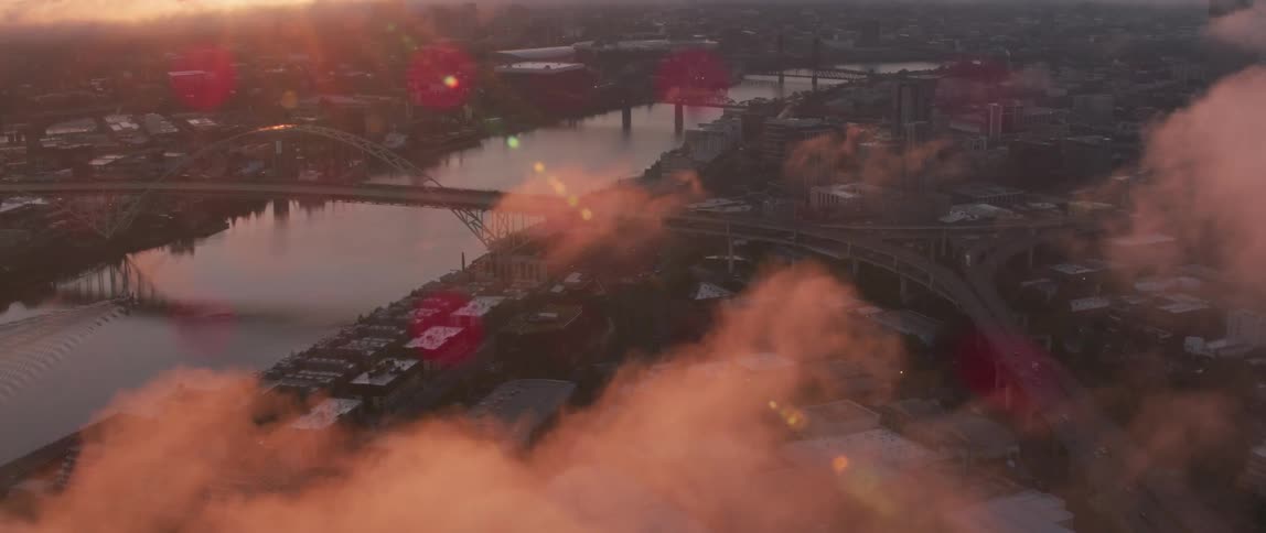 Thin clouds hover above a city at dawn