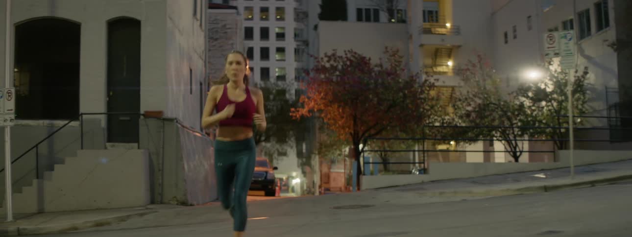 A woman jogs down a city street