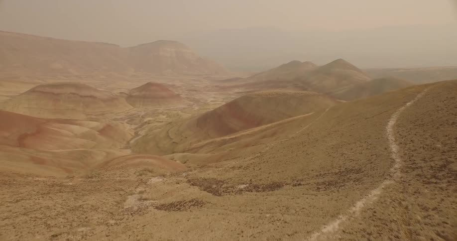 Haze is settling in the air above a desert landscape during the day