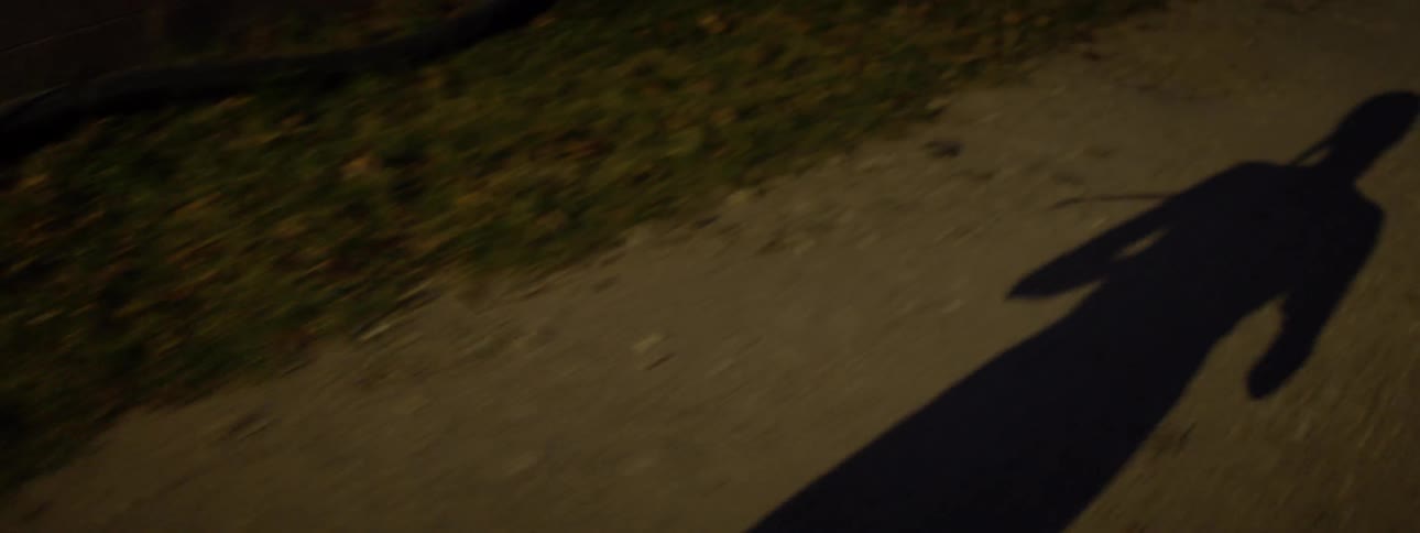 A woman's shadow is seen as she runs at night