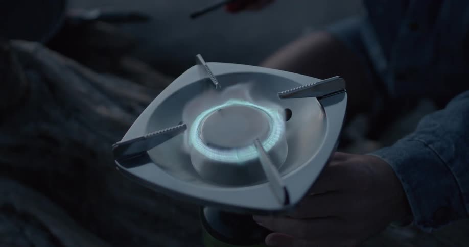 A man lights a propane camping burner