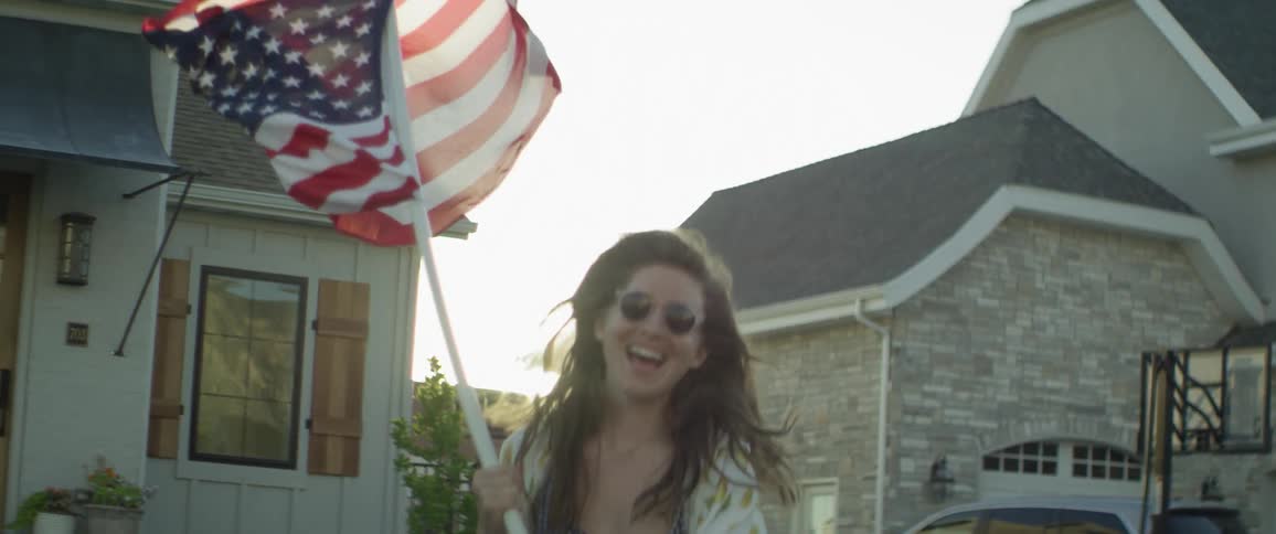 A woman runs while waving an american flag