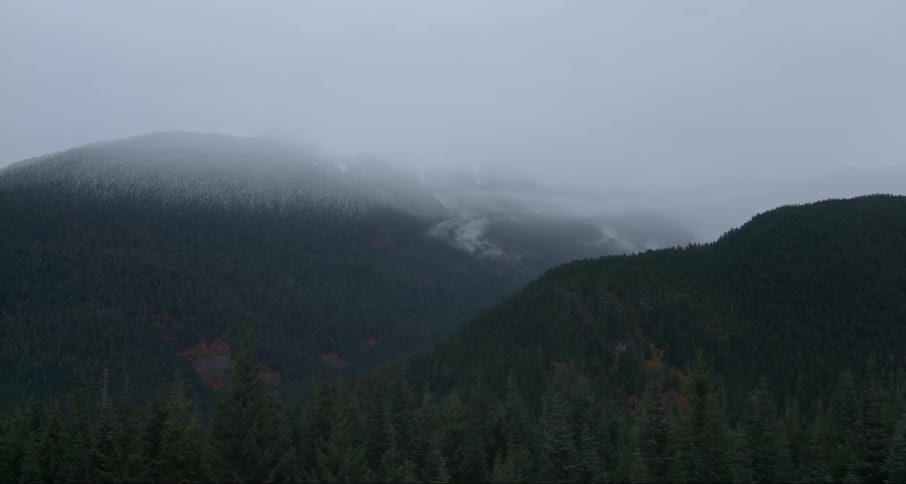 The fog rolls off the green mountains ahead