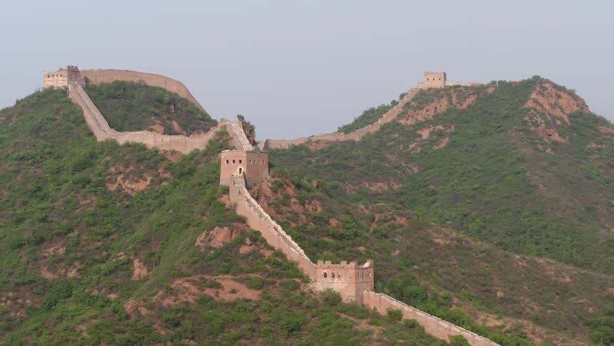 Large winding wall over grassy mountains