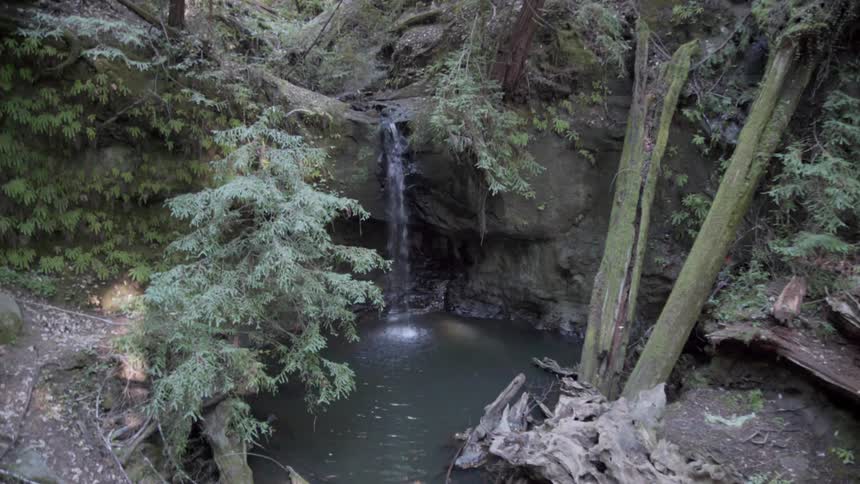 Water splashes into a pond from a waterfall