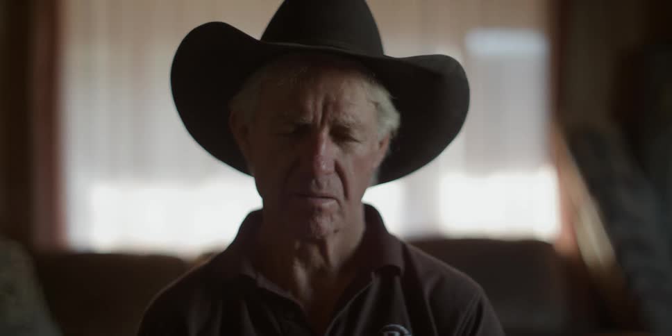 A cowboy sits inside with his eyes closed