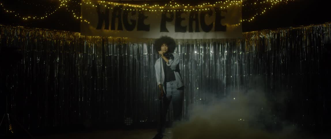 A person walks to a microphone on a stage