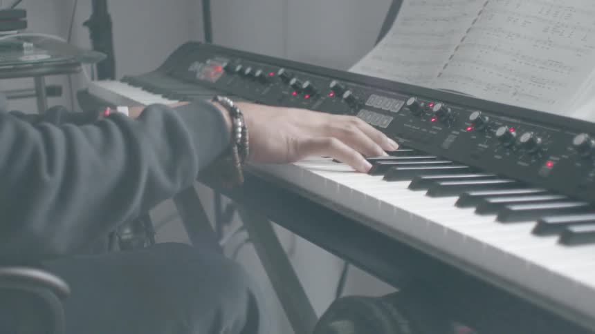 A musician plays keyboard in a music room