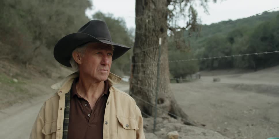 The man walks past a fence on the trail
