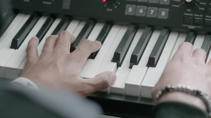 A person moves his hands along the keyboard playing