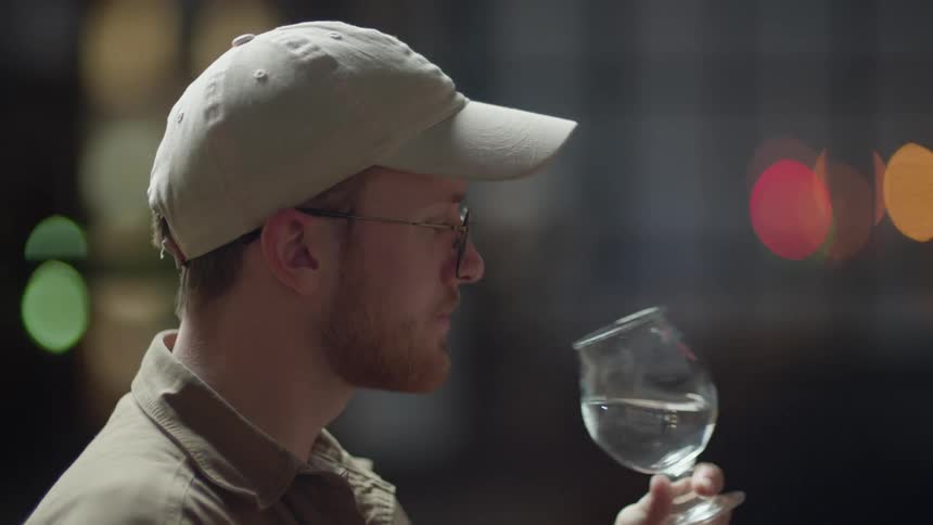 A man takes a drink from a glass