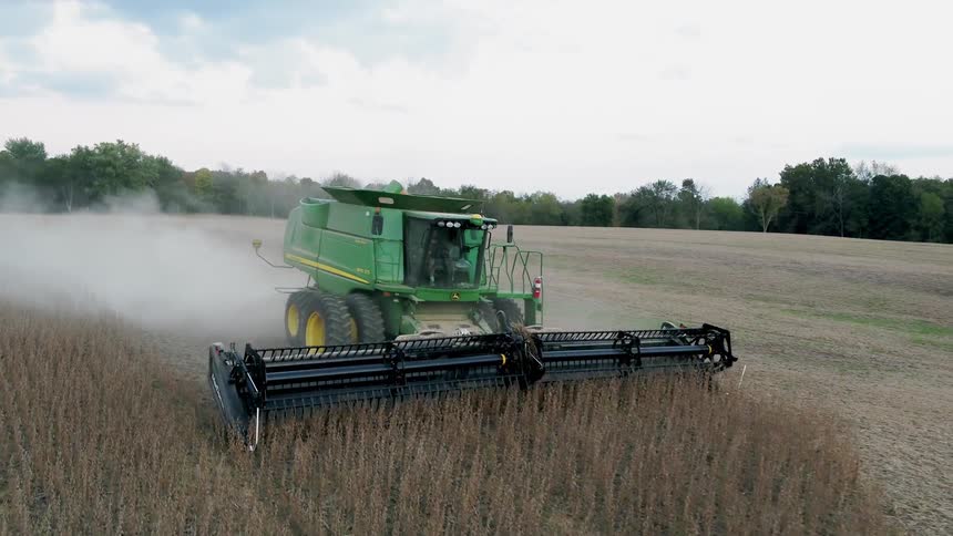 A farmer on a combine harvests his crop