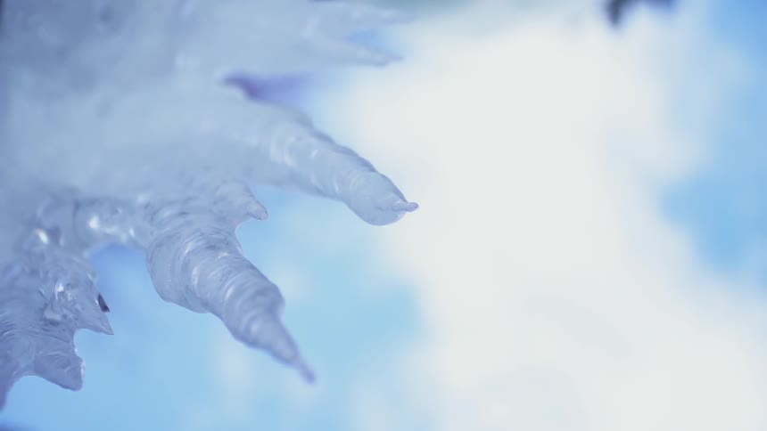 Icicles hang under a blue sky