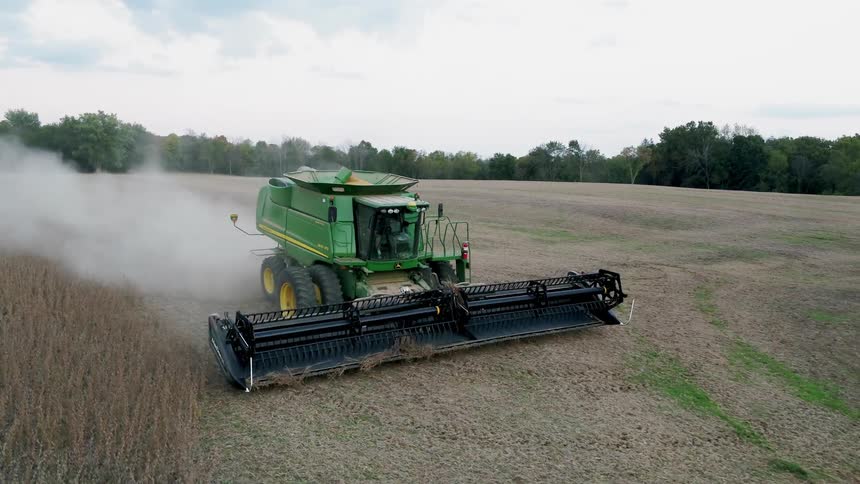 The large green tractor leaves debris behind as it works