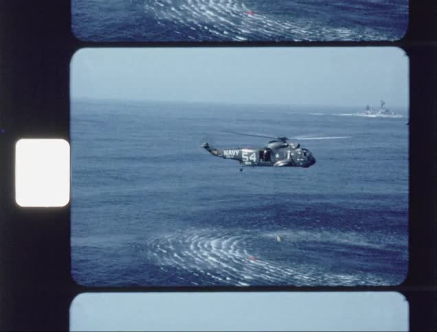 A helicopter over the water creating ripples in a rescue attempt
