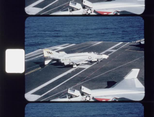 An airplane parking on an aircraft carrier