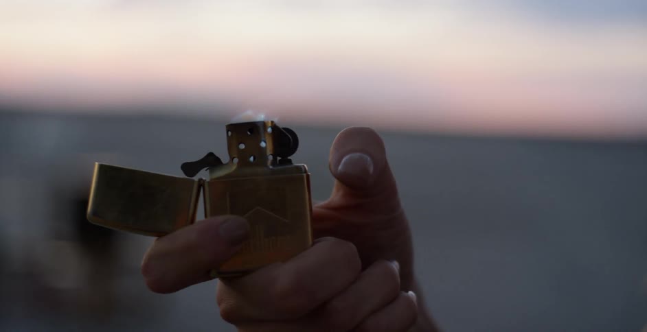 A person shields the light as it is lit