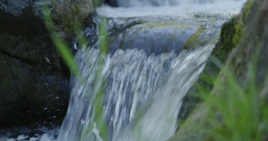 A stream is cascading over a rock ledge during the day