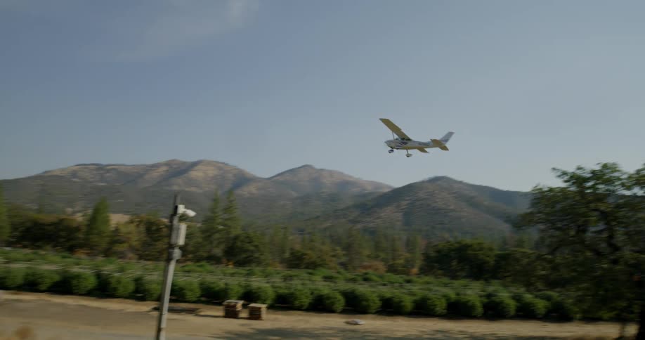 An airplane flies over a farm