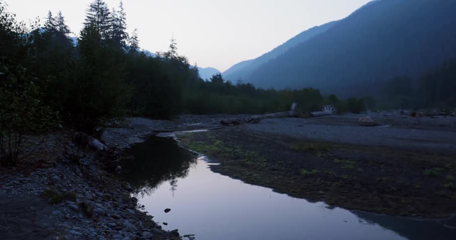 A mountain stream reflects the trees
