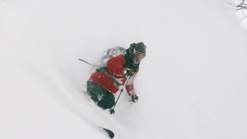 A skier turns through deep snow