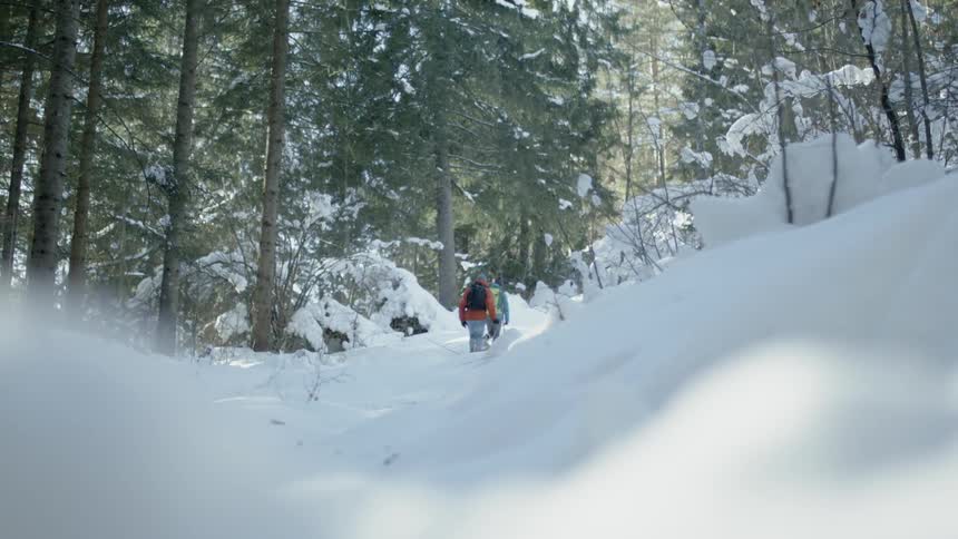 Two people hike through the snow