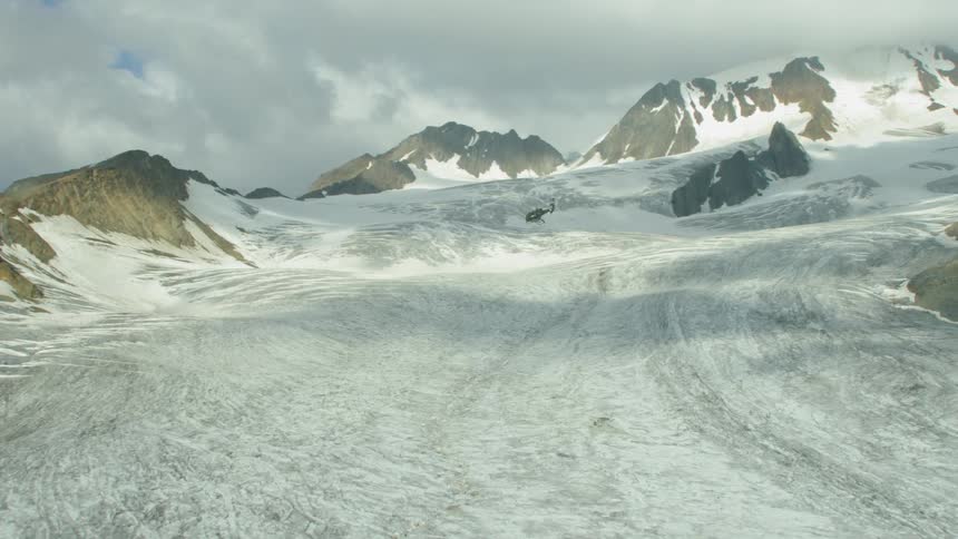 The helicopter flies up over the slope