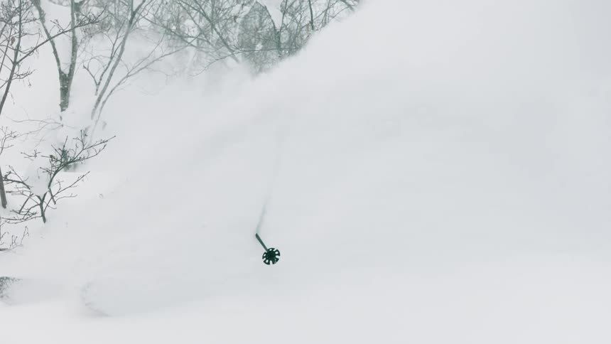 A skier glides down a snowy mountainside