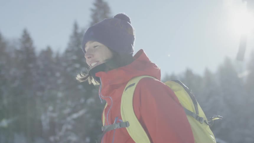 A woman smiles and talks with someone while walking outside