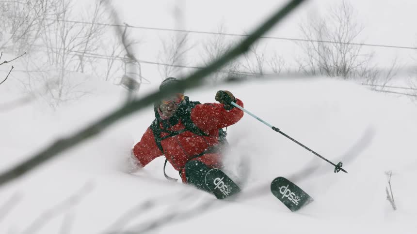 A skier turns through deep snow at a resort
