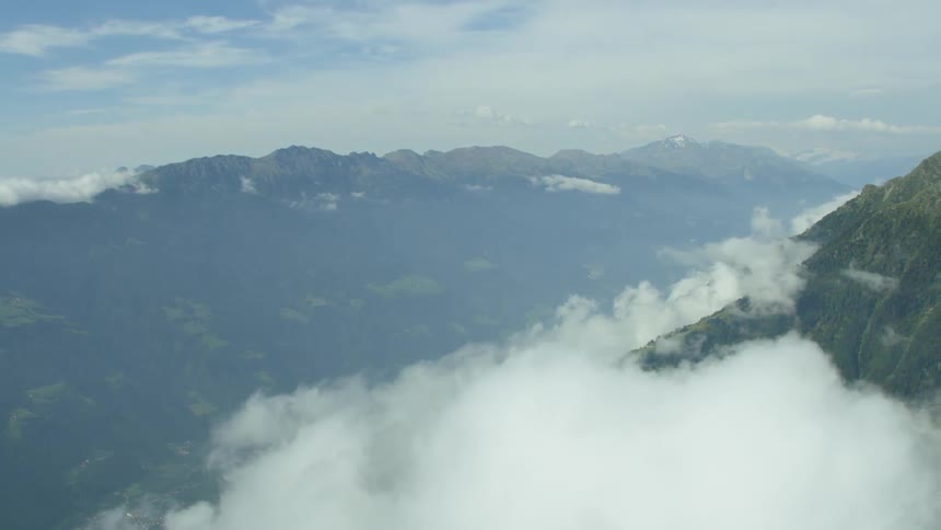 Clouds hovering near some mountaintops on a cloudy day