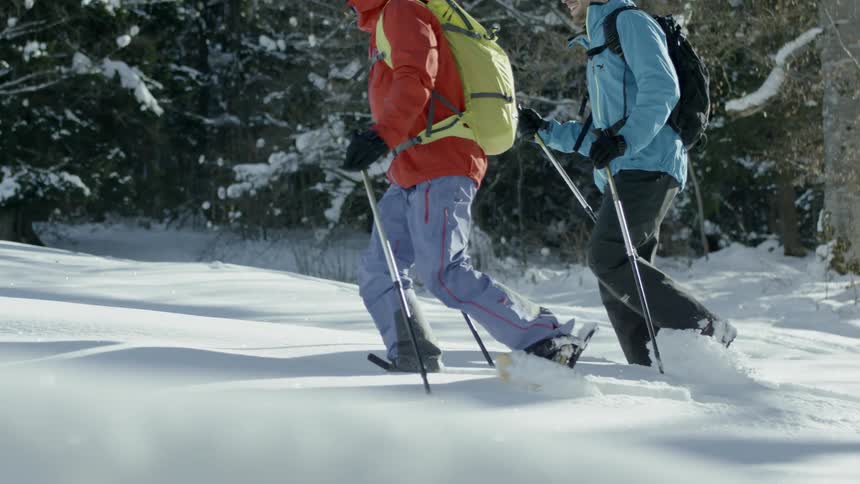 Two people hike through the snow