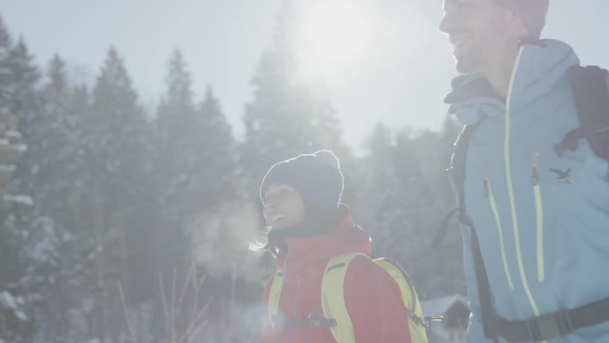 A couple are walking outside in a natural setting on a winter day