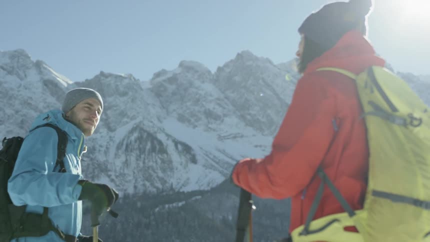 Two people on a mountain talk and smile