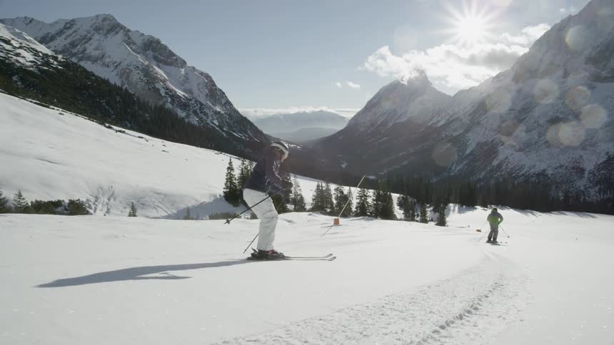 Skiers glide down a snowy mountainside