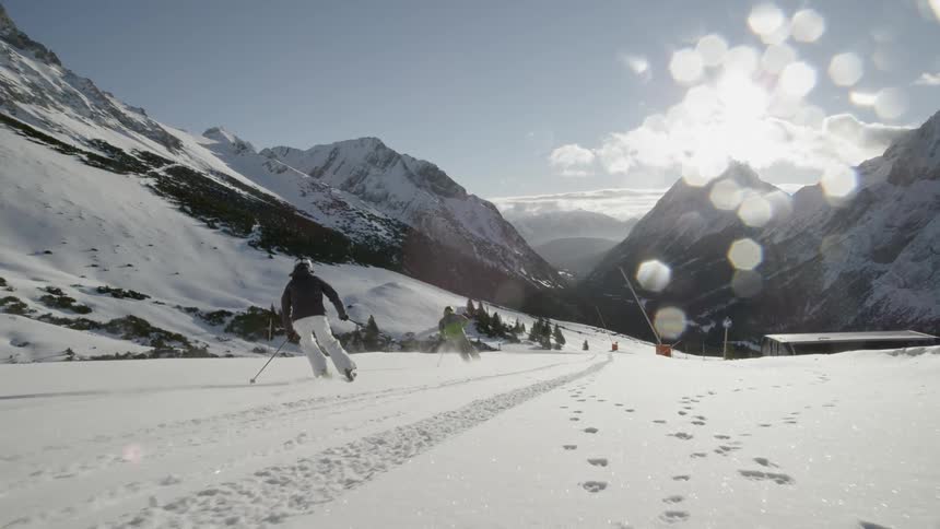 Skiers descend down the slope