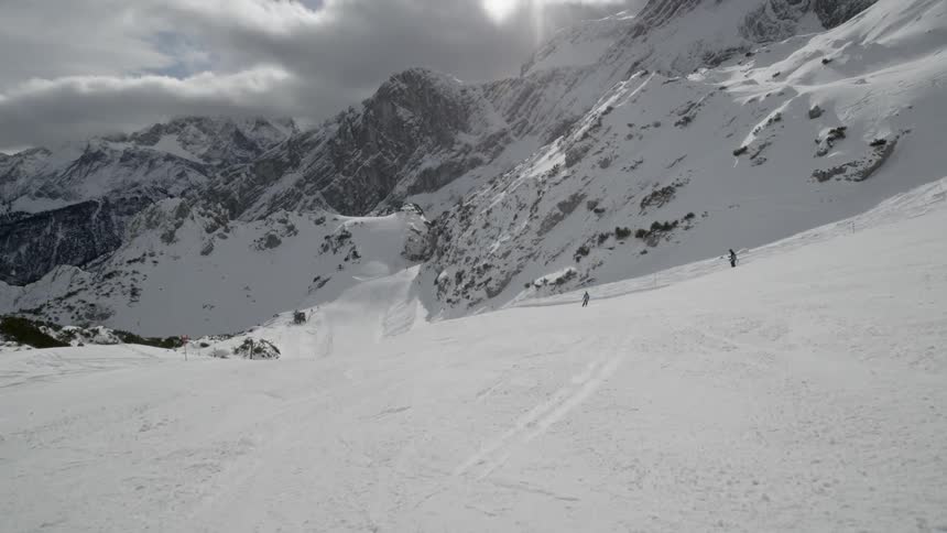 People ski down a mountain slope