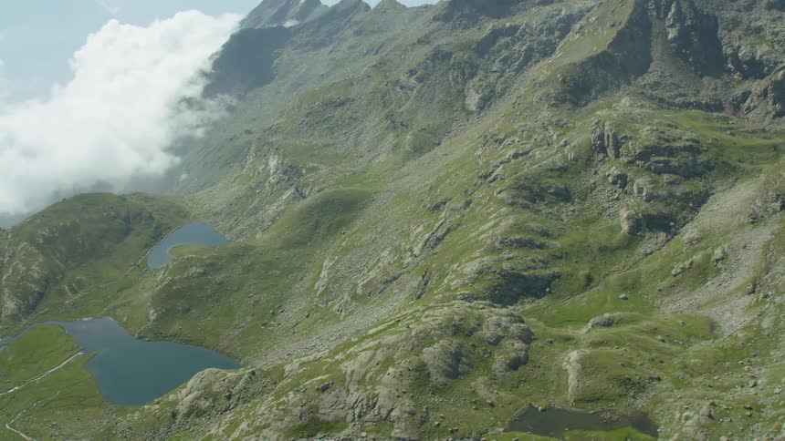 White clouds hang in a valley between tall stone mountains