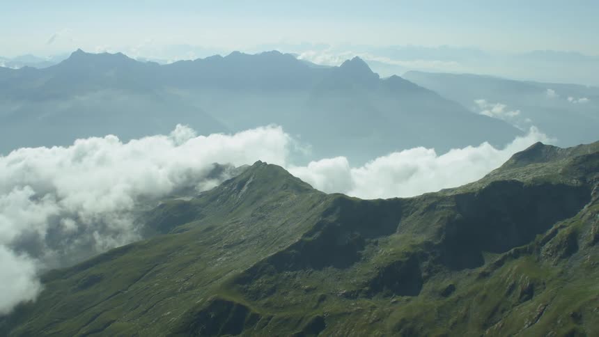 Clouds pass above and between mountains