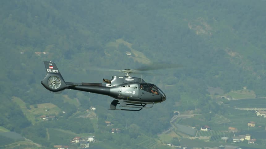 A helicopter flies high in the sky