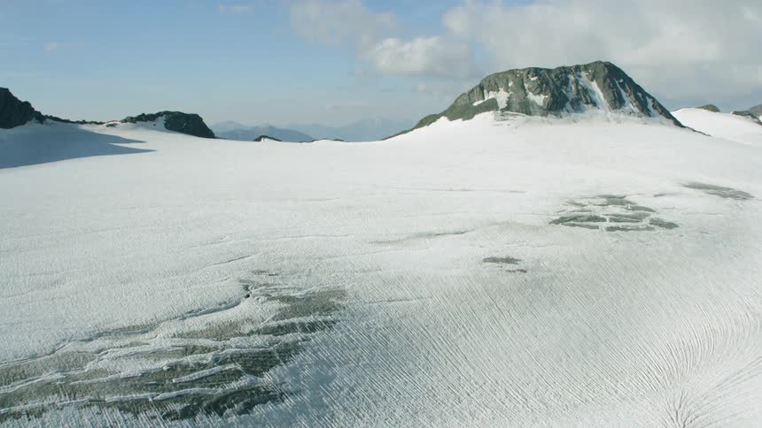 Snow covers the top of a stone mountain