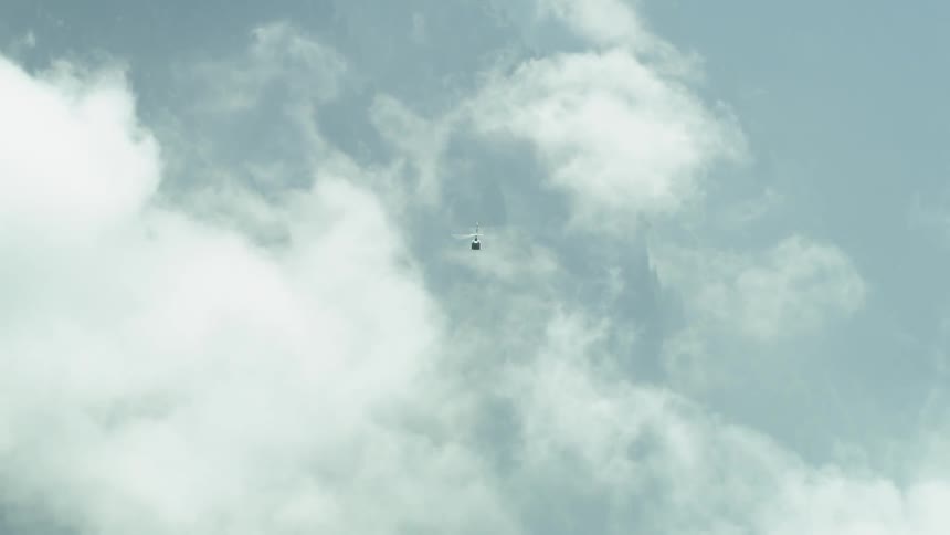 A helicopter flies high in the sky