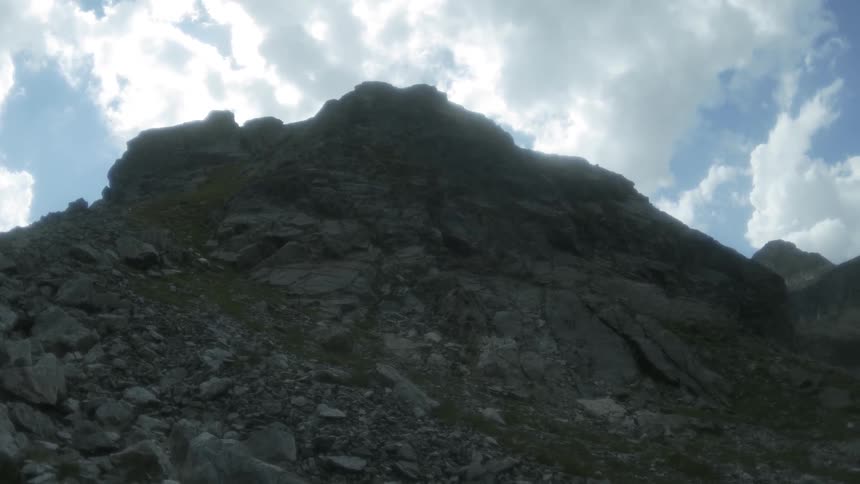 Clouds float above a rocky mountain ridge
