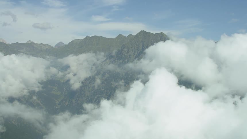 Clouds float near rocky peaks