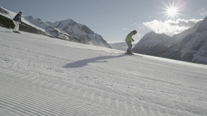 Skiers glide down a snowy mountainside