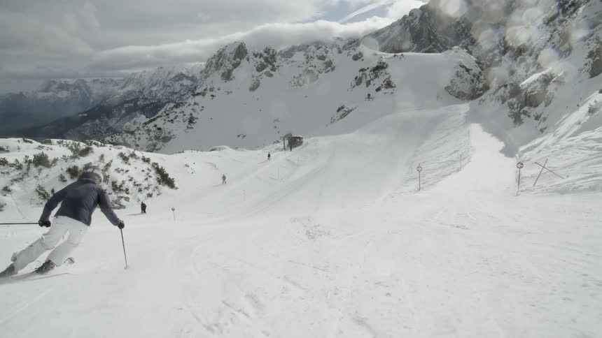 A skier glides down a snowy mountainside